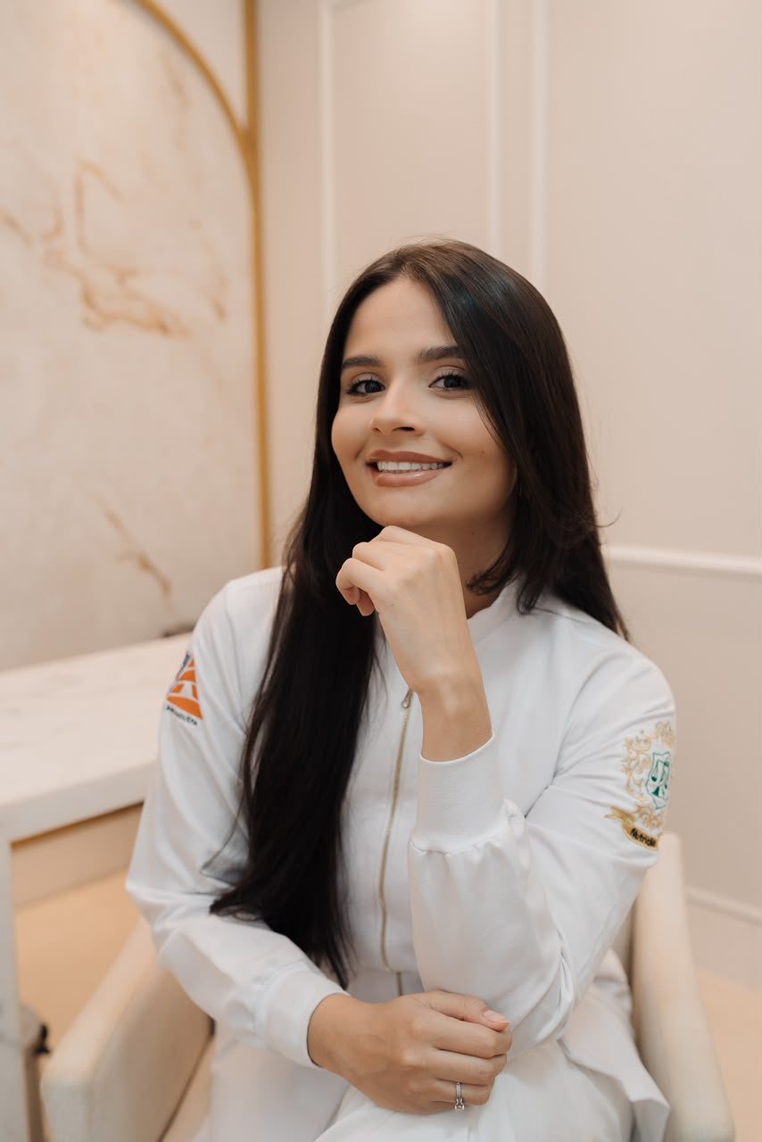 Adelaide Moraes sorrindo com a mão no queixo